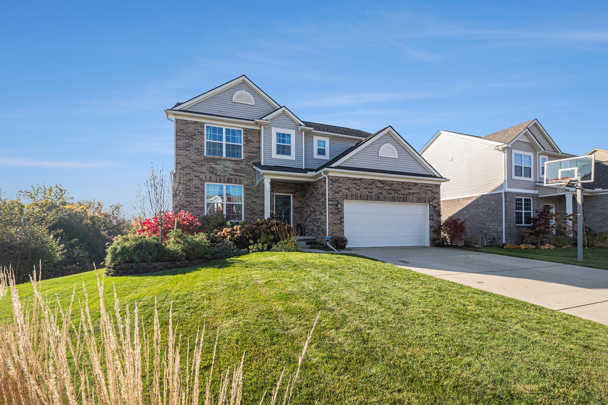 A brick two-story home above a green lawn
