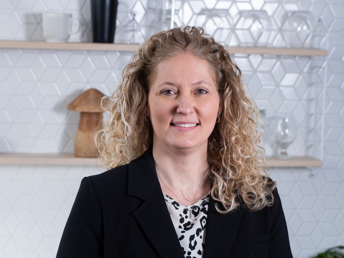 Nancy Arnold smiling in a black blazer in a bright kitchen